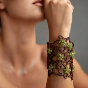 Brazalete de diseño orgánico en cuero marrón con incrustaciones de piedras semipreciosas de color verde esmeralda, joyería artesanal de autor.