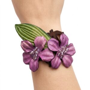 Brazalete de cuero artesanal con dos flores lila y centro de piedras semipreciosas en la muñeca.