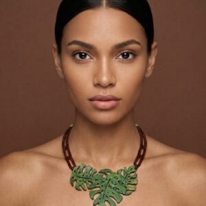 Collar de cuero verde con forma de hoja de Costilla de Adán pintado a mano con tintes ecológicos sobre modelo.