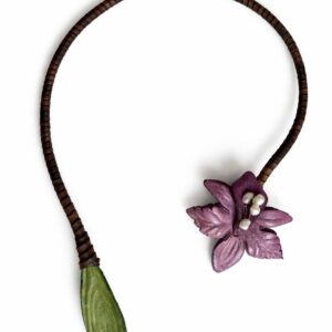 Primer plano de un Collar orquídea lila artesanal con flor natural preservada.